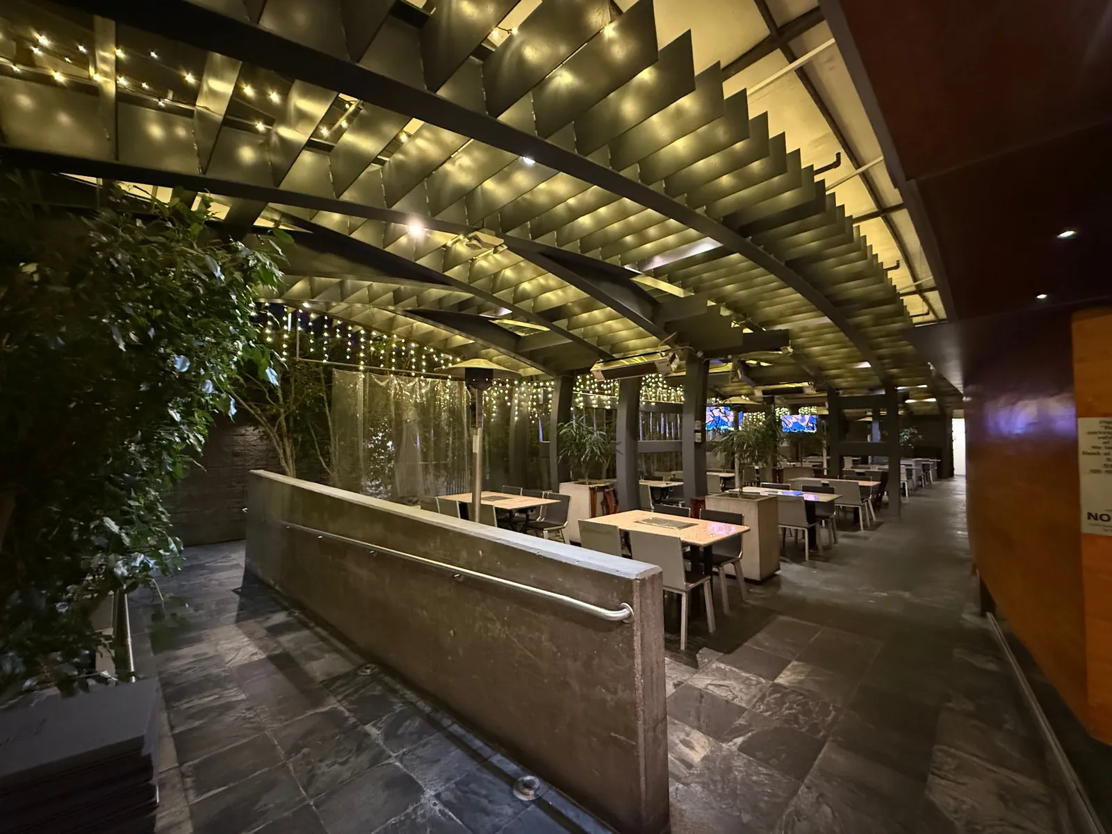 Covered garden patio with string lights and grill tables